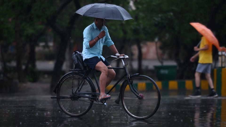 Commuters out in the light rain on the Sector 21 road, on June 25, 2023 in Noida, India. - Sunil Ghosh/Hindustan Times/Shutterstock