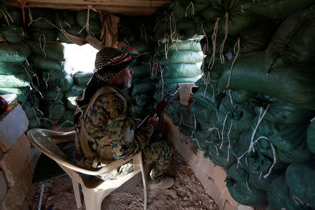 A Popular Mobilisation Forces (PMF) fighter takes his position in al-Qaim, Iraq, near the border with Syria, November 27, 2018. REUTERS/Alaa al-Marjani