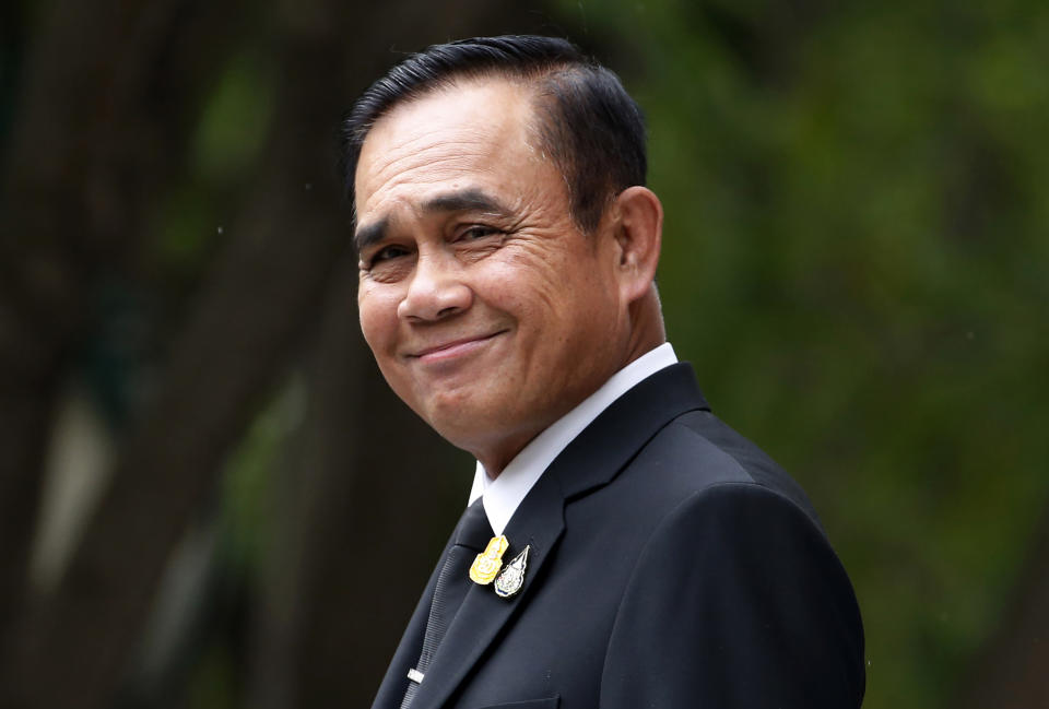 FILE - In this Thursday, June 6, 2019, file photo, Thailand's Prime Minister Prayuth Chan-ocha smiles and talks reporters before a meeting at the government house in Bangkok, Thailand. The leader of Thailand's military government has revoked a number of special executive legal orders and vowed to stop issuing more as he prepares to lead the next elected civilian government. (AP Photo/Sakchai Lalit, File)