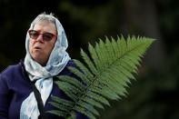 A woman holds a fern during a vigil for the victims of the mosque attacks during an ecumenical celebration in Christchurch, New Zealand, March 21, 2019. REUTERS/Jorge Silva