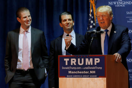 FILE PHOTO: Then U.S. Republican presidential candidate Donald Trump welcomes his sons Eric (L) and Donald Jr. (C) to the stage at one of the New England Council's "Politics and Eggs' breakfasts in Manchester, New Hampshire November 11, 2015. REUTERS/Brian Snyder/File Photo