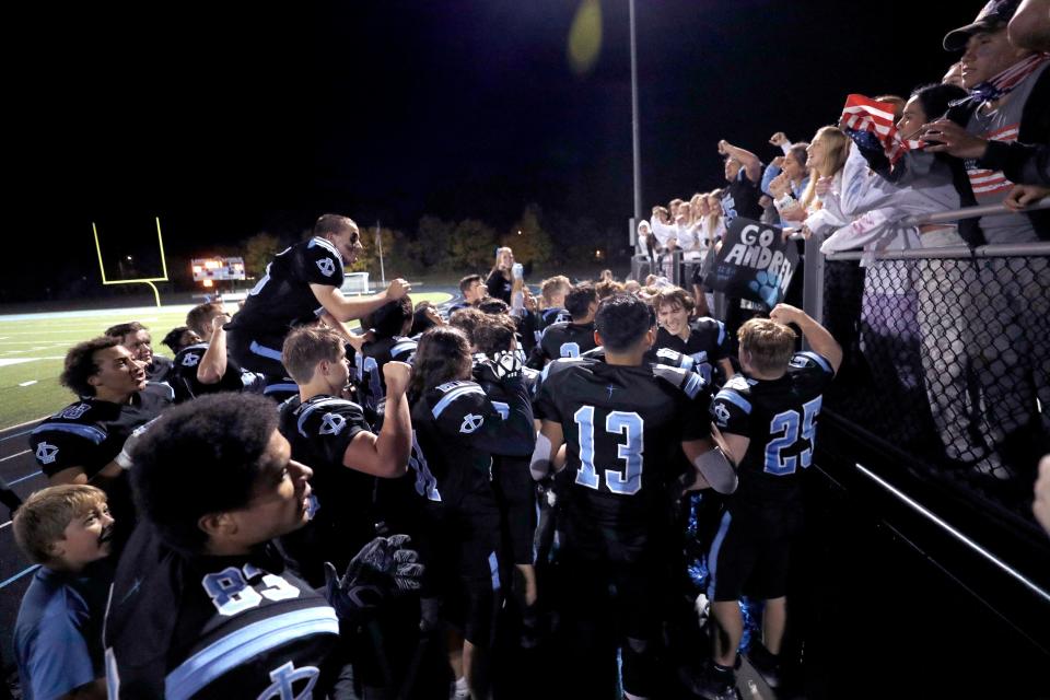 Lansing Catholic players celebrate with fans after defeating Pewamo-Westphalia, Friday, Oct. 21, 2022, in Lansing. Lansing Catholic won 42-7.