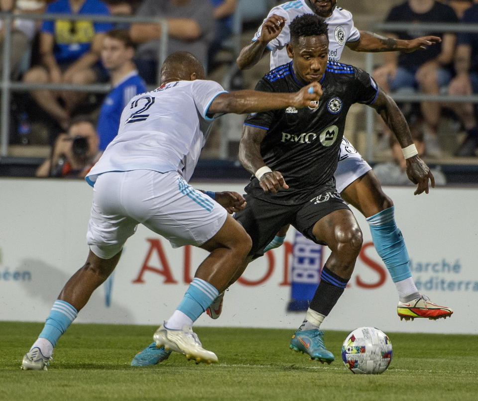 CF Montreal's Romell Quioto brings the ball forward as New England Revolution's Andrew Farrell (2) tries to block the pass during first-half MLS soccer match action in Montreal, Saturday, Aug. 20, 2022. (Peter McCabe/The Canadian Press via AP)