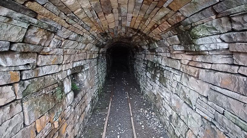 Interior of a mine level showing stonework and railway lines