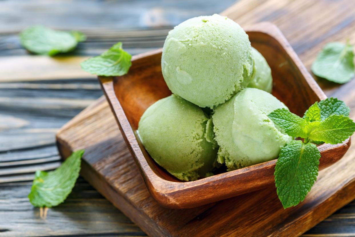 Homemade mint ice cream in bowl on old table, selective focus.