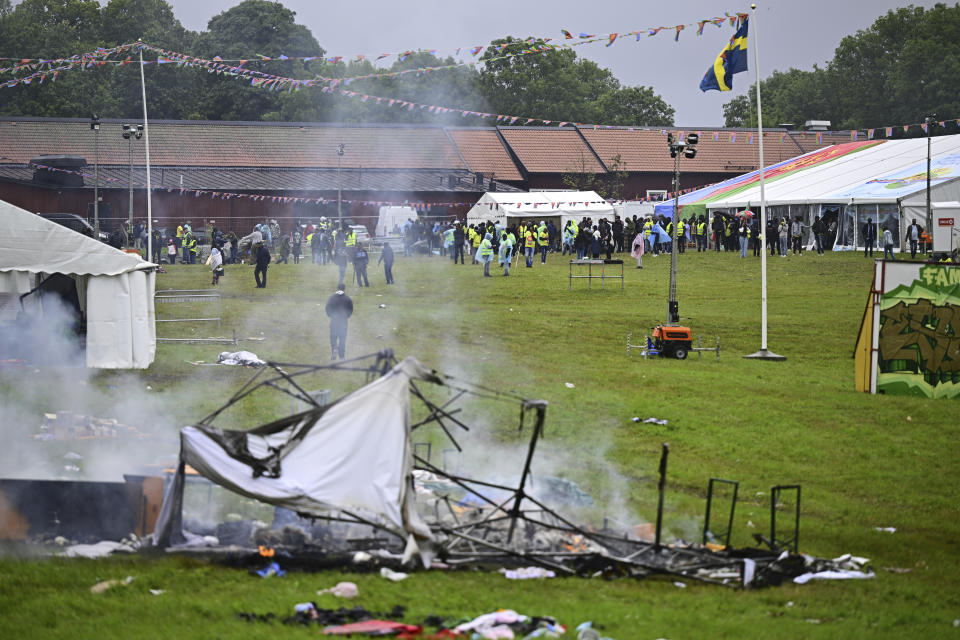 Smoke billows from a burning tent at the Eritrean cultural festival "Eritrea Scandinavia" in Stockholm, Thursday, Aug. 3, 2023. A violent clash at an Eritrea-themed culture festival in Sweden has caused a chaos as about a thousand anti-Eritrean government protesters stormed the outdoor festival venue throwing stones, setting fire on booths and tearing down tents. (Magnus Lejhall/TT News Agency via AP)