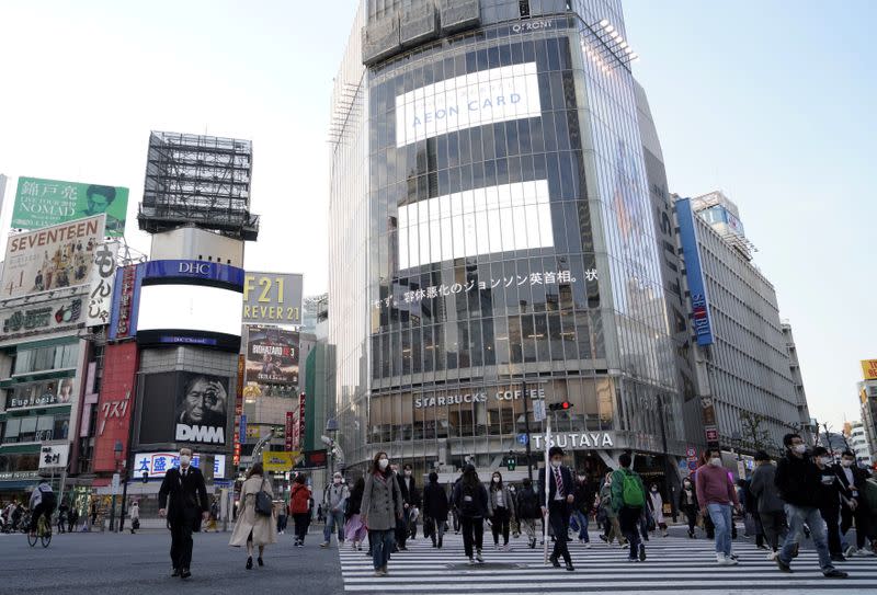 Pedestrians wearing protective masks make their way in Tokyo