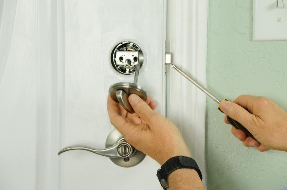 A close up of a person trying to fix or open a lock. 