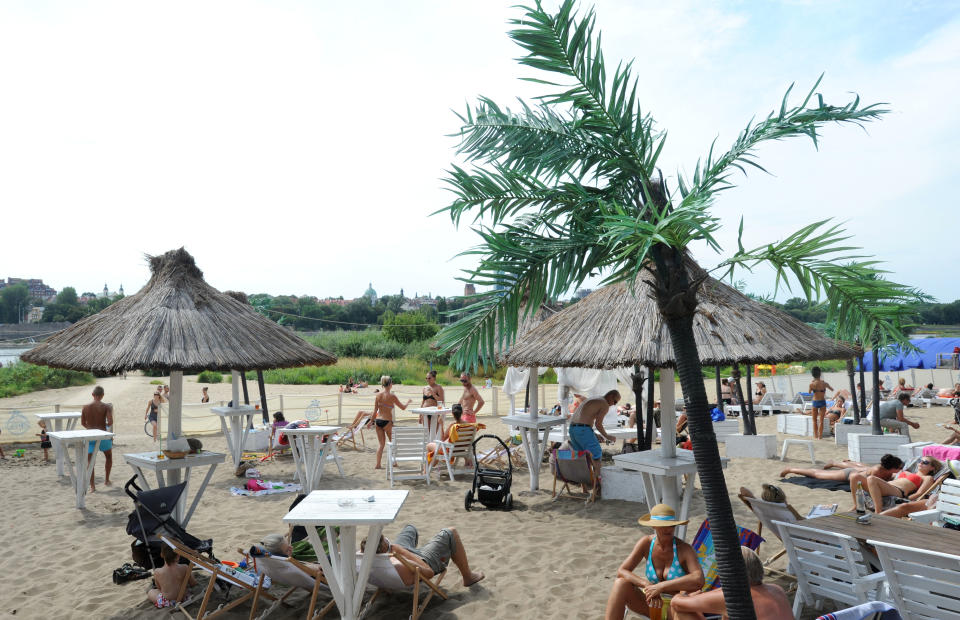 This Aug. 4, 2013 photo shows people on a beach on the right side of the Vistula river near the zoo in Warsaw, Poland. A rare occurrence in Europe’s big cities, Warsaw has natural river banks and three beaches. (AP Photo/Alik Keplicz)