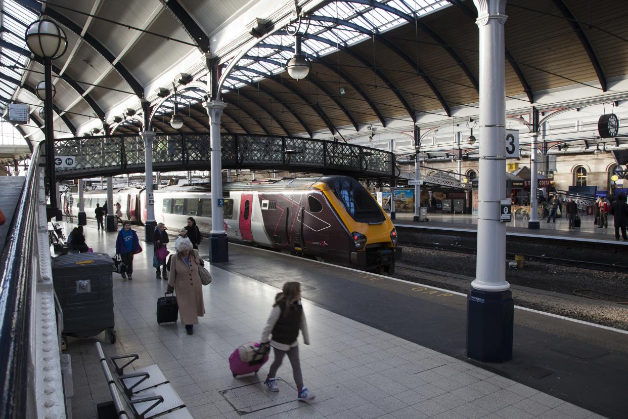 Passengers walking along a platform with luggage Newcastle Central Station. (Photo by: Loop Images/Universal Images Group via Getty Images)