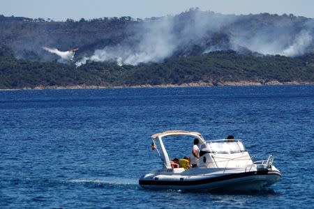 A Canadair firefighting plane drops water to extinguish a forest fire on La Croix-Valmer from Cavalaire-sur-Mer, near Saint-Tropez, France, July 25, 2017. REUTERS/Jean-Paul Pelissier