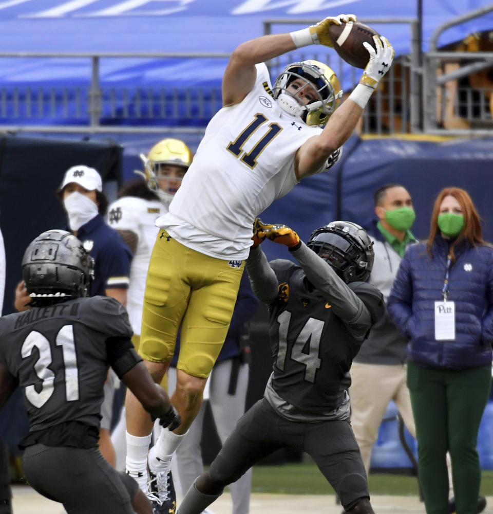 Notre Dame wide receiver Ben Skowronek pulls in a pass for a touchdown against Pitt defensive backs Erick Hallett and Marquis Williams in the second quarter of an NCAA college football game, Saturday, Oct. 24, 2020, in Pittsburgh. (Matt Freed/Pittsburgh Post-Gazette via AP)