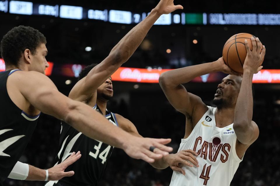 Cleveland Cavaliers' Evan Mobley looks to shoot past Milwaukee Bucks' Giannis Antetokounmpo and Brook Lopez during the first half of an NBA basketball game Friday, Nov. 25, 2022, in Milwaukee. (AP Photo/Morry Gash)