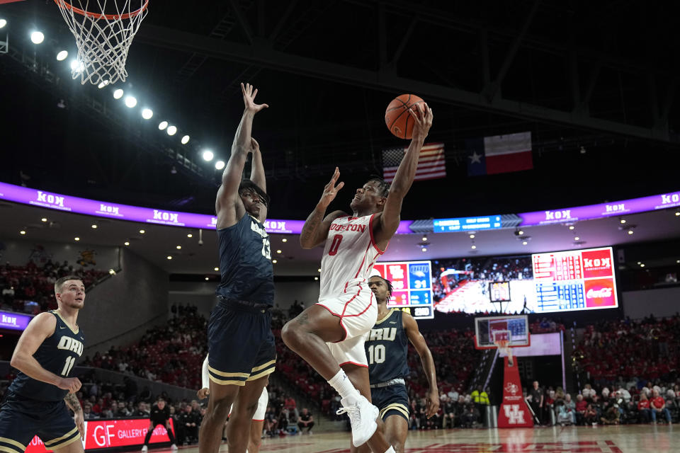 Houston's Marcus Sasser (0) goes up for a shot as Oral Roberts's Nate Clover III (13) defends during the second half of an NCAA college basketball game Monday, Nov. 14, 2022, in Houston. (AP Photo/David J. Phillip)
