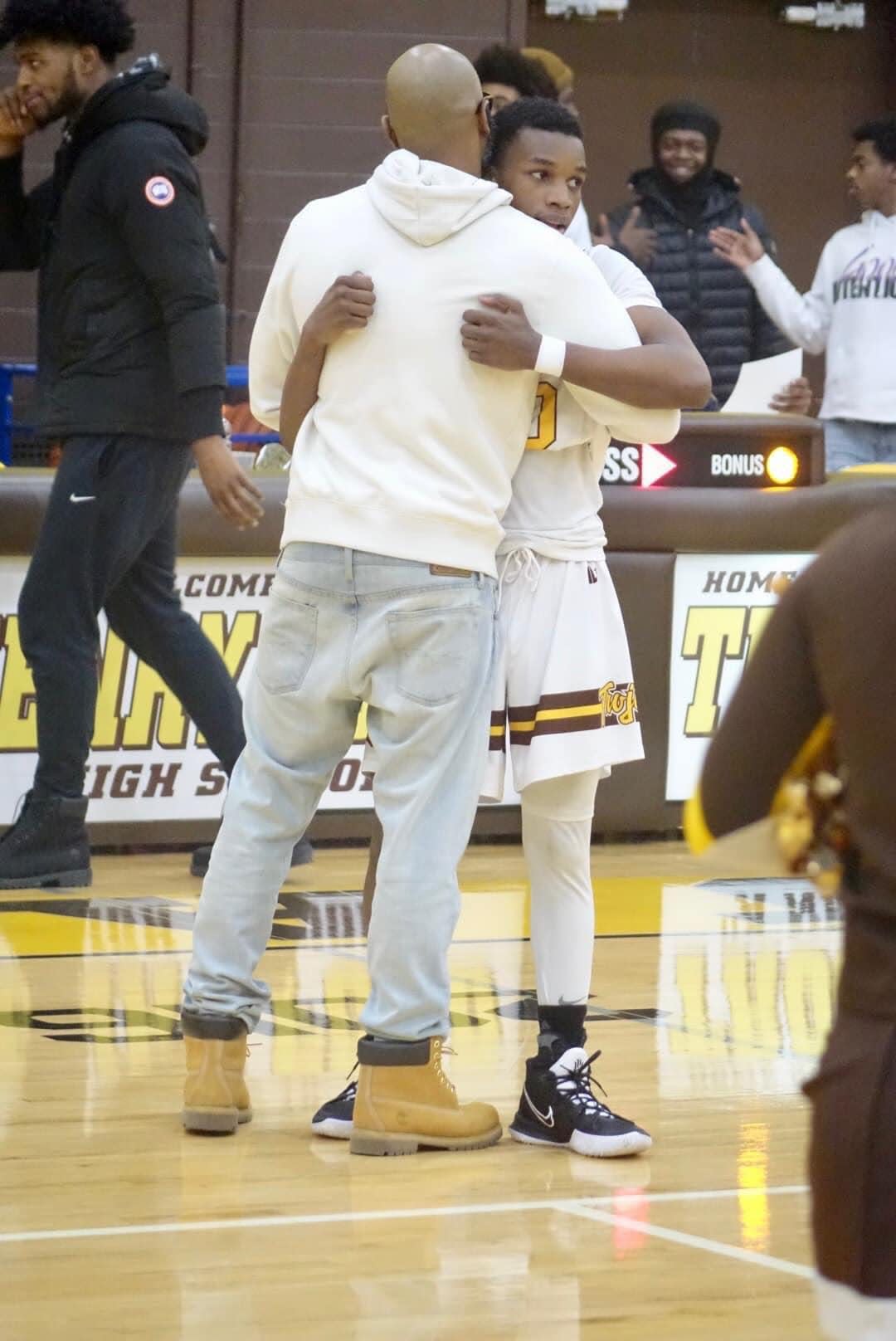 Terrance Coker Sr. and his son, Terrance Coker Jr., share a hug on the basketball court. Coker Jr. was killed last month.