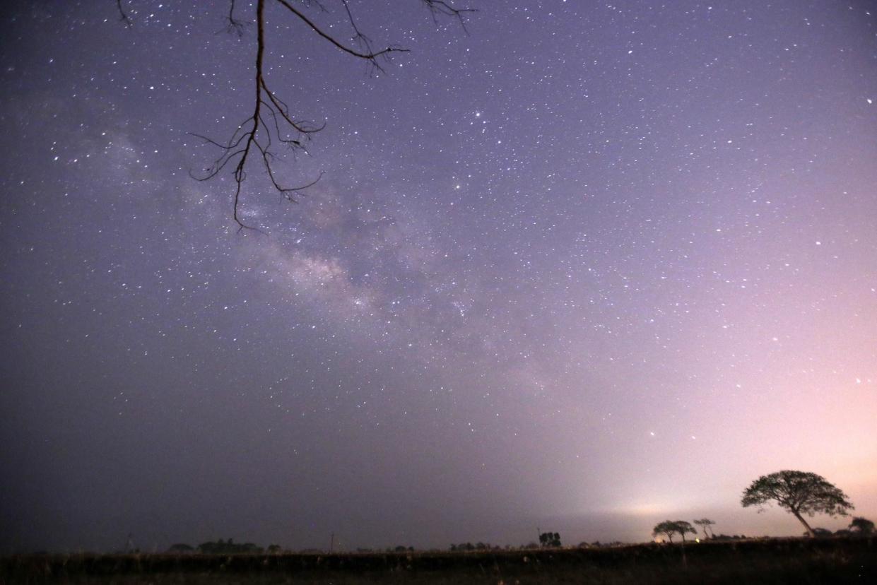 This long-exposure photograph taken on April 23, 2015 on Earth Day shows Lyrids meteors shower passing near the Milky Way in the clear night sky of Thanlyin, nearly 14miles away from Yangon (Ye Aung Thu/AFP/Getty Images)