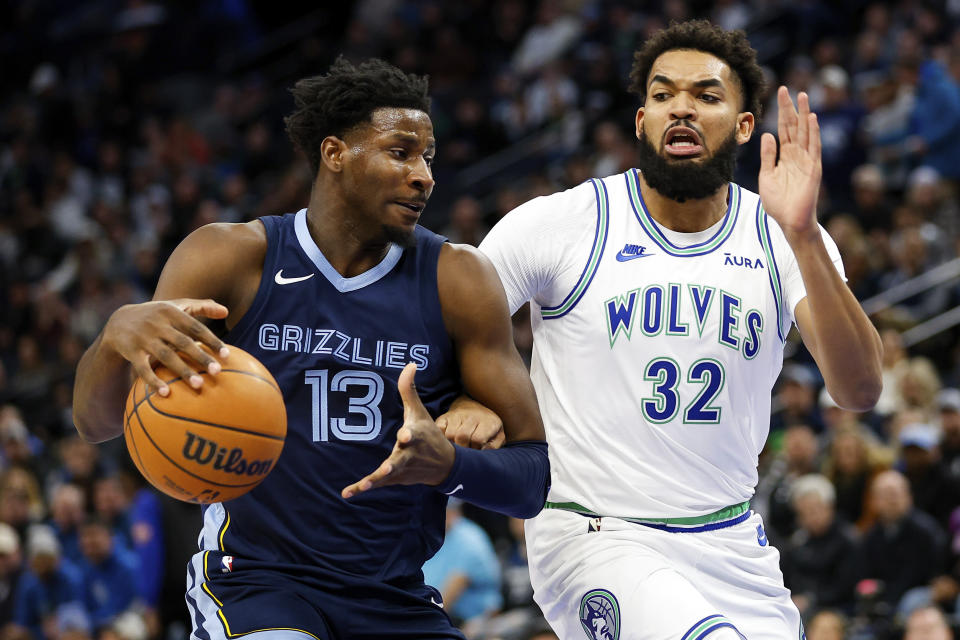 Memphis Grizzlies forward Jaren Jackson Jr. (13) works toward the basket as Minnesota Timberwolves center Karl-Anthony Towns (32) defends during the first half of an NBA basketball game Thursday, Jan. 18, 2024, in Minneapolis. (AP Photo/Matt Krohn)