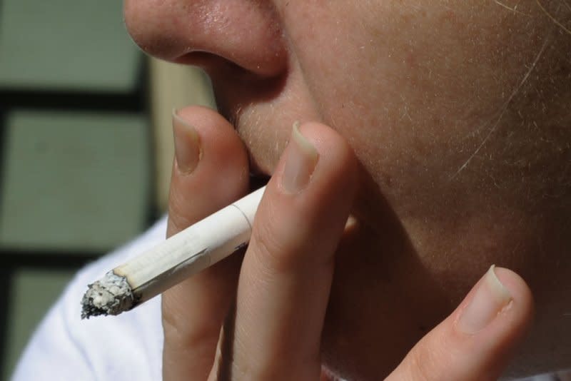 A woman smokes a cigarette in Arlington, Va., on June 12, 2009. On March 20, 1997, the Liggett Group, fifth-largest U.S. tobacco company, agreed to admit that smoking was addictive and caused health problems. File Photo by Alexis C. Glenn/UPI