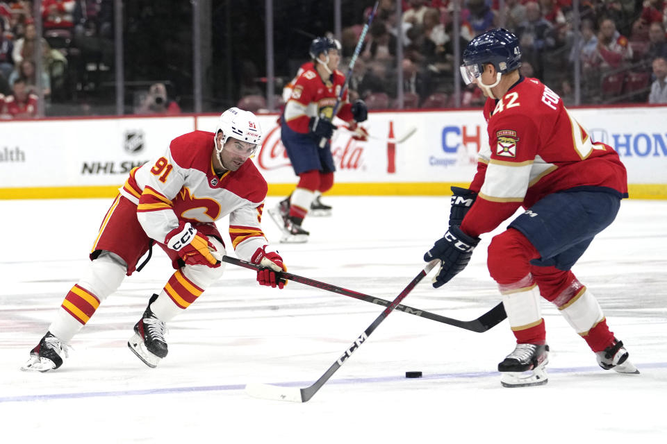 Calgary Flames center Nazem Kadri (91) skates with the puck as Florida Panthers defenseman Gustav Forsling (42) defends during the first period of an NHL hockey game, Saturday, March 9, 2024, in Sunrise, Fla. (AP Photo/Lynne Sladky)