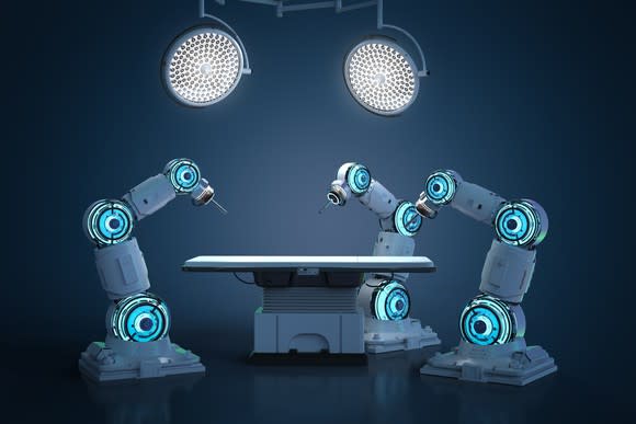 An artist's rendering of three robots around an operating table.