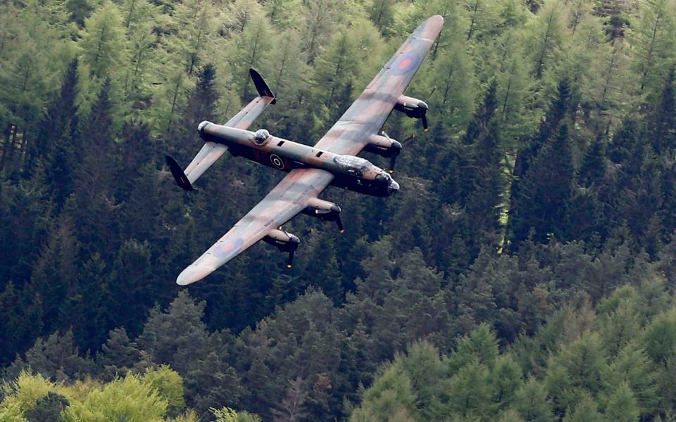 A Lancaster bomber swoops over Derwent Reservoir to mark the 70th anniversary of the raids  - Credit: REUTERS/Darren Staples