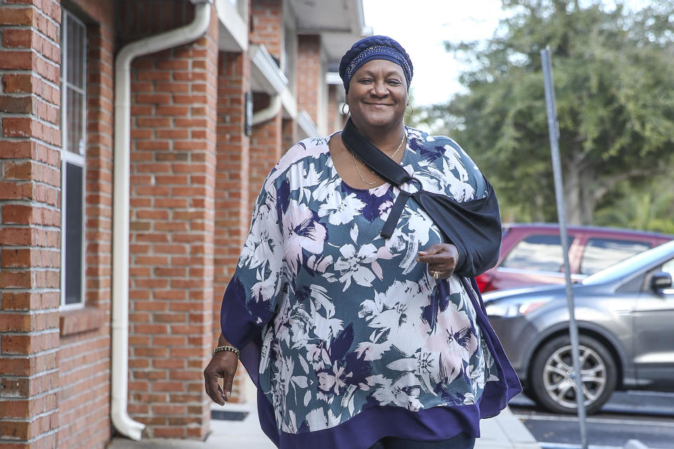 Vanessa Akinniyi poses front of her doctor's office in Jacksonville, Fla., Thursday, Jan. 13, 2022. Akinniyi was stuck in denial about diabetes until a care manager from her health insurer coaxed her out. The nurse fed Akinniyi information about her condition and talked about potential problems she could run into like vision loss. (AP Photo/Gary McCullough)