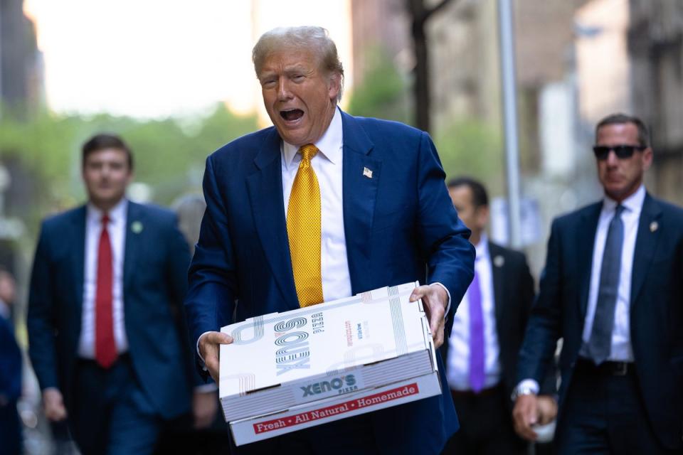 Donald Trump carries boxes of pizza for the FDNY Engine 2, Battalion 8 firehouse on May 02, 2024 in New York City (Getty Images)