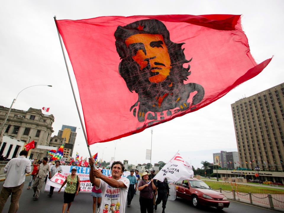 A man carries a flag with the image of Che Guevara during a march against Peruvian President Alan Garcia in downtown Lima April 13, 2010. A group of protesters who oppose Garcia's government demanded he resign.