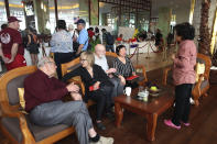 Passengers from the cruise ship Westerdam talk each other as they watch dance performance at a hotel in Phnom Penh, Cambodia, Wednesday, Feb. 19, 2020. Cambodian authority invited the passengers to entertain them. Having finally reached a friendly port willing to accept them and stepped ashore after weeks of uncertainty at sea, hundreds of the cruise ship passengers eyed warily over fears of a new virus are now simply trying to find a way home. (AP Photo/Heng Sinith)