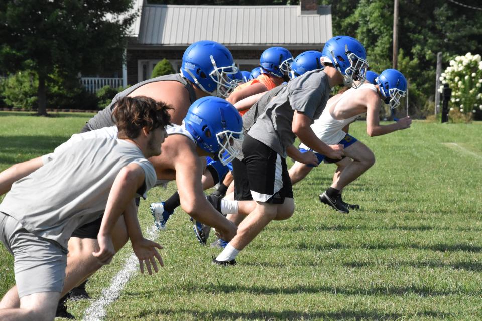 Mitchell's linemen take off from the goal line during conditioning at the end of their first official practice of the season.