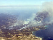 <p>An aerial view shows plumes of smoke rising in the air from burning wildfires in the outskirts of Bormes-les-Mimosas, French Riviera, July 26, 2017. (Nadine Achoui-Lesage/AP) </p>