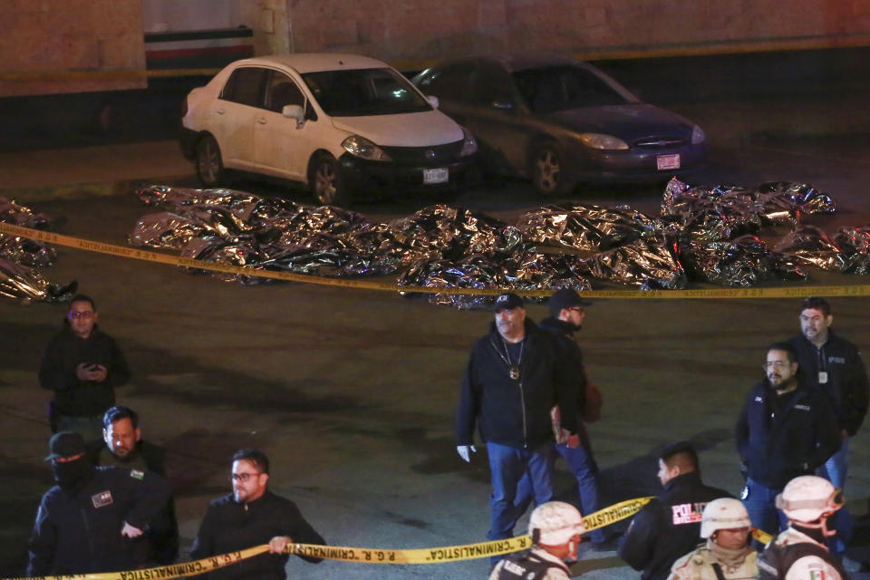 The bodies of migrants lay covered after a deadly fire broke out at an immigration detention center in Ciudad Juarez, Mexico, Tuesday, March 28, 2023. (AP Photo/Christian Chavez)