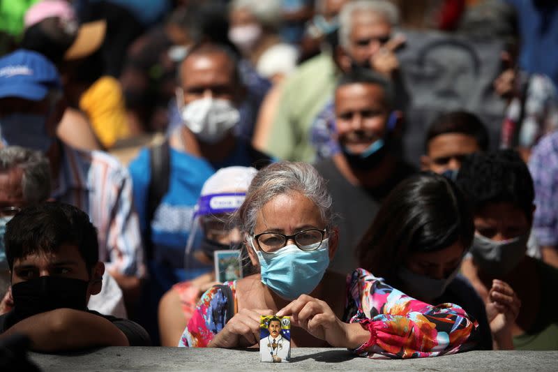 People gather outside of the Our Lady of La Candelaria church, where the remains of Jose Gregorio Hernandez, a doctor known for treating the poor during the Spanish flu pandemic a century ago, are being exhumed, in Caracas