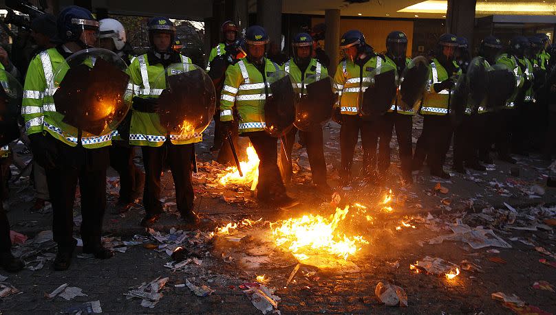 La Policía británica apagando fuego en la entrada de Millbank Tower, 2010