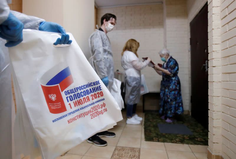 Members of an electoral commission visit local residents during a nationwide vote on constitutional reforms in Moscow