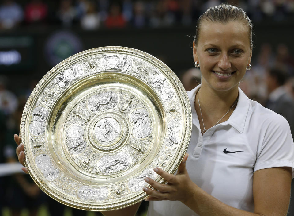 FILE - In this July 5, 2014, file photo, Petra Kvitova, of Czech Republic, holds the trophy after winning the women's singles final against Eugenie Bouchard at the All England Lawn Tennis Championships in Wimbledon, London. Two-time Wimbledon champion Petra Kvitova said on Tuesday June 25, 2019, that she has resumed training and will decide later this week whether she's fit enough to play at the All England Club this year. (AP Photo/Sang Tan, File)