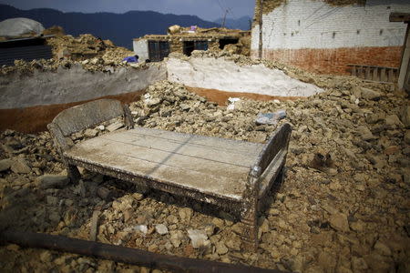 A bed lies on the debris of a collapsed house after the April 25 earthquake at a village on the outskirts of Lalitpur May 8, 2015. REUTERS/Navesh Chitrakar