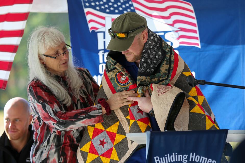 Gail Belmont, the Founder & Executive Director of Quilts of Honor, wraps Marine LCpl. Bryan Chambers in a quilt made for him, on Saturday, Oct. 1, 2022, in Attica, Ind.
