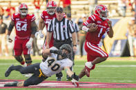 Louisiana-Lafayette quarterback Levi Lewis (1) evades a tackle by Appalachian State linebacker Logan Doublin (40) before scoring a touchdown in the first half of the Sun Belt Conference championship NCAA college football game against Appalachian State in Lafayette, La., Saturday, Dec. 4, 2021. (AP Photo/Matthew Hinton)