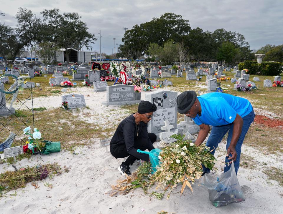 A week after Eleecia Smith's casket at Greenwood Cemetery in Daytona Beach was disinterred so it could be moved to the correct burial spot, Smith's aunt, Dianne Gibson, and brother, Bobby Smith, returned to tend to her sandy grave.