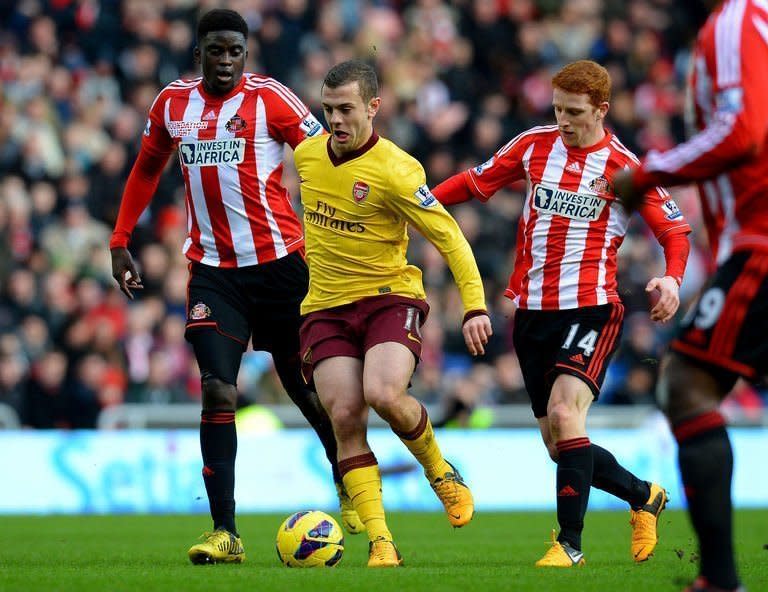 Arsenal midfielder Jack Wilshere (C) holds off Sunderland midfielders Alfred N'Diaye (L) and Jack Colback, at The Stadium of Light, on February 9, 2013. Santi Cazorla fired 10-man Arsenal to a 1-0 away win, but the Gunners' triumph was marred by Wilshere's thigh injury