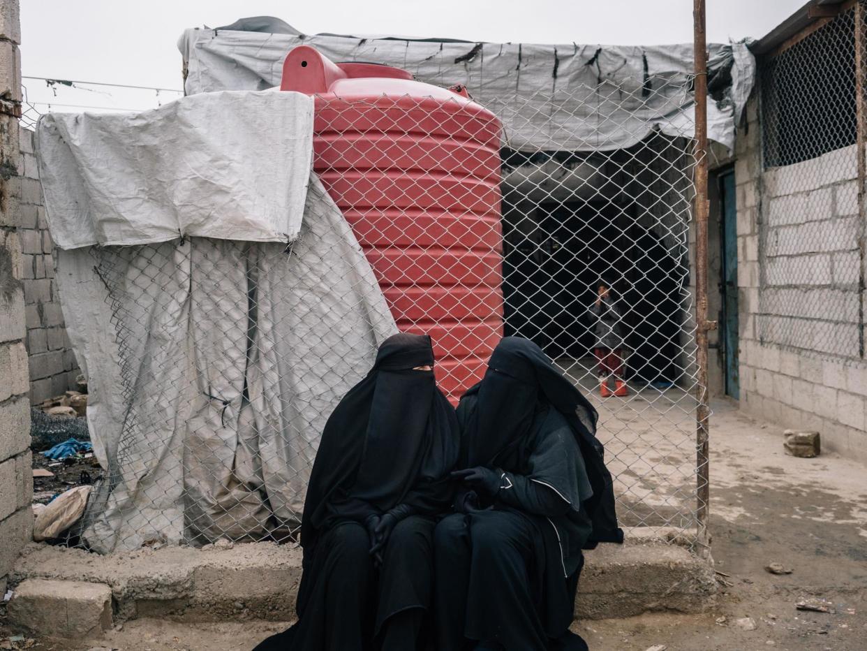 Russian women sit outside a shop in the foreigner's section of al-Hol camp in December 2019: The Washington Post