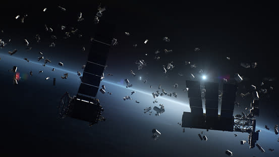  A rendering in low orbit above Earth, showing many pieces of space debris of various sizes floating about. 