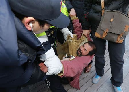 Security personnel detain Kim Ki-jong, a member of a pro-Korean unification group who attacked the U.S. ambassador to South Korea Mark Lippert at a public forum, in central Seoul March 5, 2015. REUTERS/Kim Ju-sung/Yonhap