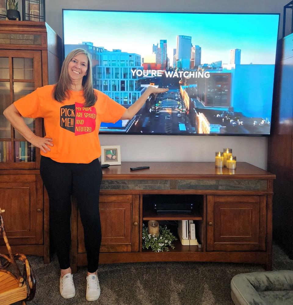 Tracy Haines of Coshocton wearing the T-shirt she wore during a recent appearance on "The Price is Right" with the television she won. She also got a dartboard with cabinet and two leather loveseats from the long running game show based in California.