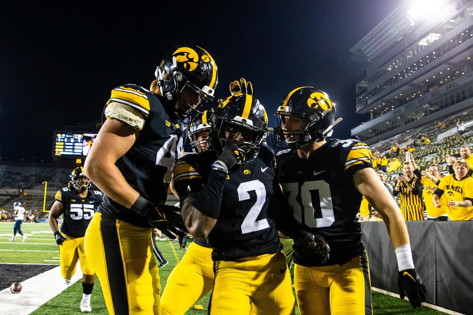 Iowa defensive back Terry Roberts, center, celebrates with teammates Max Llewellyn, left, and Quinn Schulte after intercepting during a NCAA football game against Nevada, Sunday, Sept. 18, 2022, at Kinnick Stadium in Iowa City, Iowa. The play was overturned due to a penalty against Iowa.