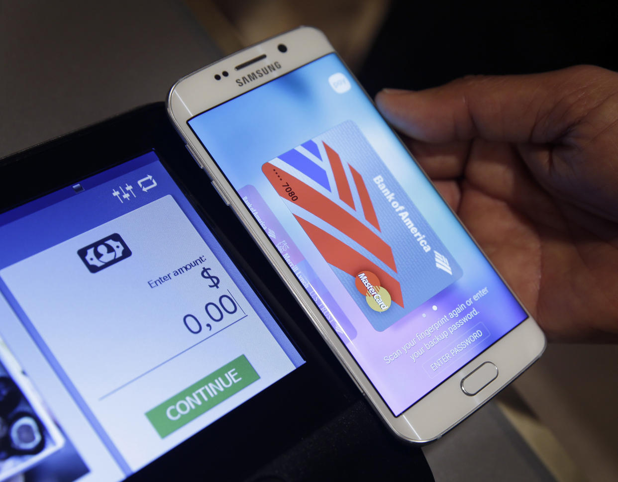 FILE - In this Aug. 6. 2015, file photo, a Samsung employee demonstrates Samsung Pay using a Galaxy S6 Edge Plus in New York. Mobile wallets come in different digital forms. There are device specific platforms, such as Apple Pay and Samsung Pay, which are compatible with Apple and Samsung devices, respectively. Google Pay works with multiple platforms, including Android devices. (AP Photo/Seth Wenig, File)