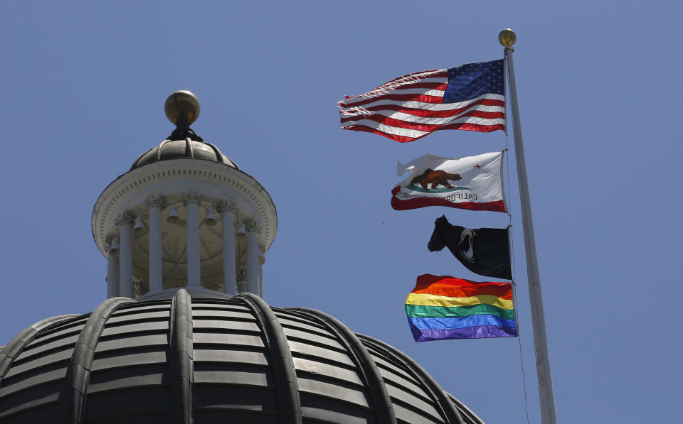 The rainbow Pride flag flutters from the flag pole at the state Capitol in Sacramento, Calif., Monday, June 17, 2019. California's governor has signed a law he says will help military service members who were discharged under "don't ask, don't tell" policies to reestablish eligibility for Veterans Affairs benefits. Gov. Gavin Newsom said Saturday, Sept. 17, 2022, many veterans who were discharged because of sexual or gender identities don't know how to access benefits they might be eligible for. The law requires the state to create a grant program to help LGBTQ veterans through the process. (AP Photo/Rich Pedroncelli, File)
