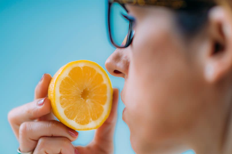 Woman smelling the scent of a lemon
