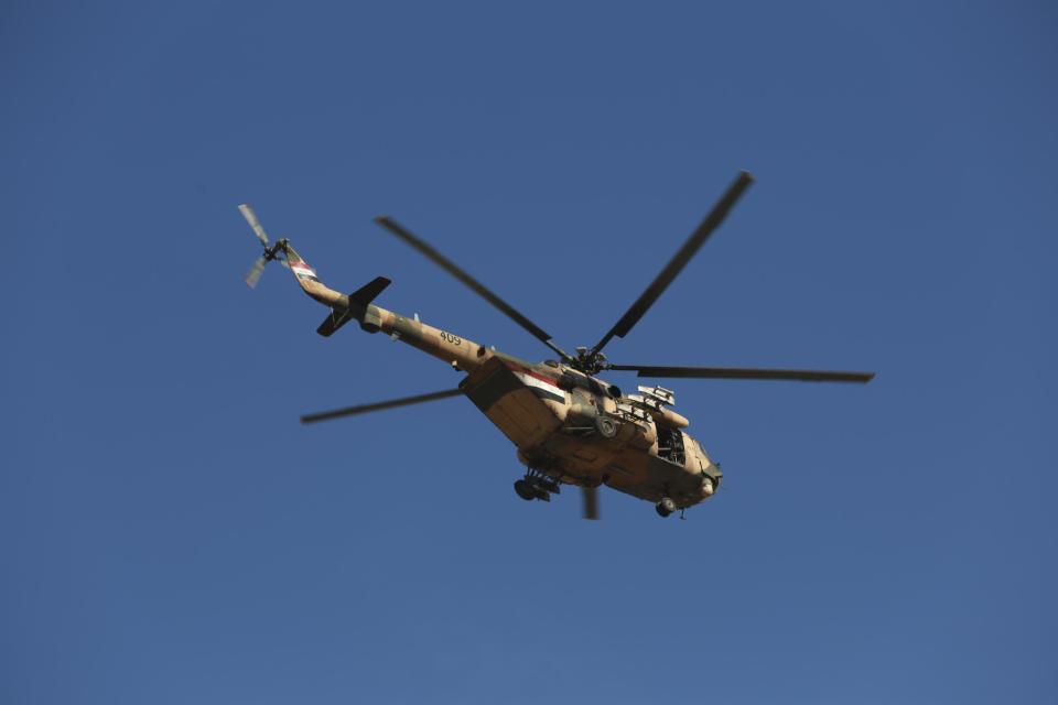 An Iraqi air force helicopter flies over Mosul as Iraqi security forces fight against Islamic State militants on the eastern side of Mosul, Iraq, Thursday, Jan. 12, 2017. Small stalls and carts have sprung up outside the bombed-out restaurants and cafes in eastern Mosul, selling fresh vegetables, cigarettes and cellphones to the thousands of civilians still living in neighborhoods where the Iraqi military has driven out the extremists of the Islamic State group. (AP Photo/ Khalid Mohammed)